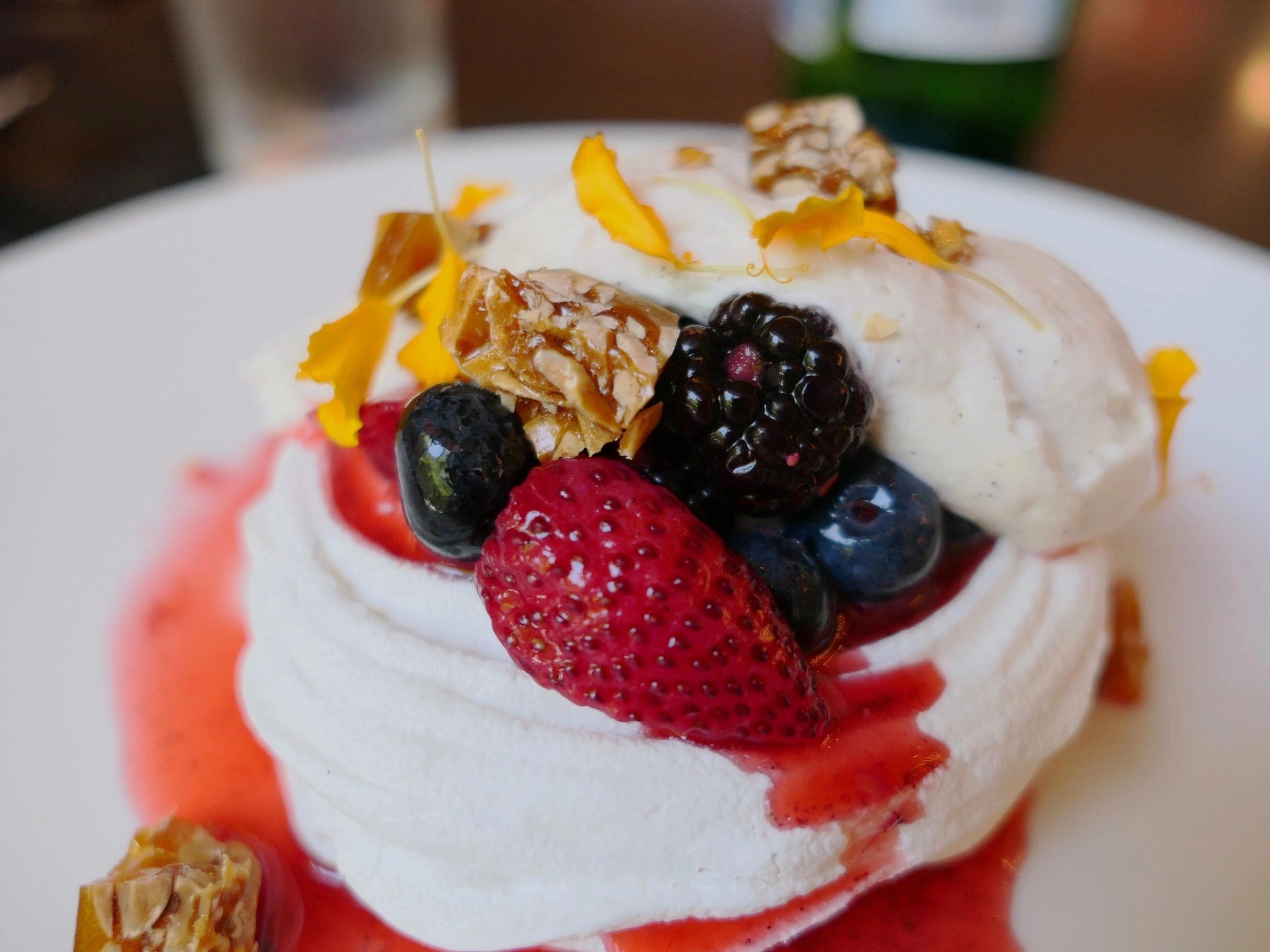 Creamy plated dessert with berries and sauce
